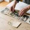Родовые сценарии в отношениях: женские руки раскладывают старые семейные фотографии трёх поколений