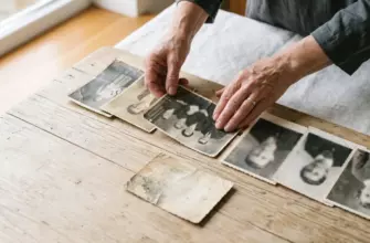 Родовые сценарии в отношениях: женские руки раскладывают старые семейные фотографии трёх поколений